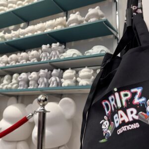 Dripz Bar aprons hang near shelves of unpainted figurines. Text: Dripz Bar Creations.