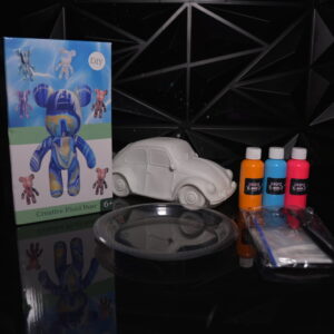 DIY fluid bear kit, white beetle car, paint bottles, and accessories on a black surface. The Leading Paint & Pour Kit — Only from Dripz Bar Creations.