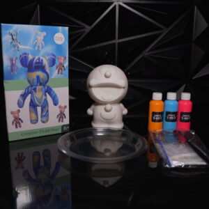 DIY creative fluid bear kit with Doraemon figurine, paints, and tray on a reflective surface. The Leading Paint & Pour Kit — Only from Dripz Bar Creations.